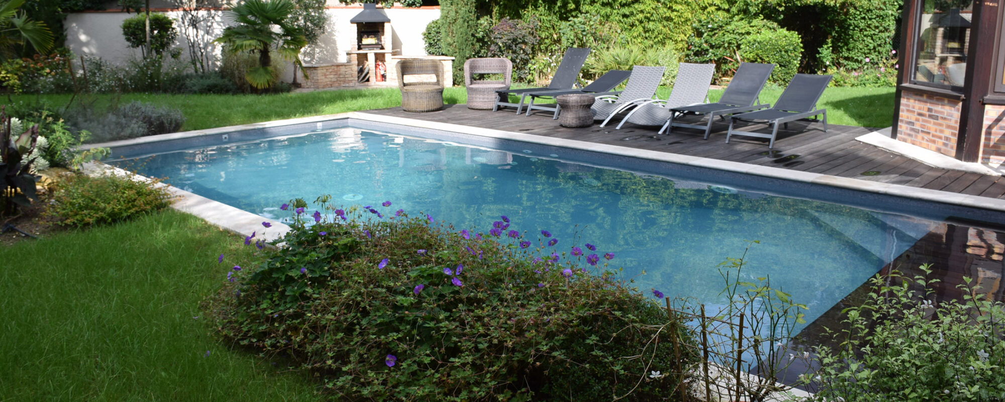 Piscine rectangulaire 9x4 avec volet motorisé , margelles en pierres naturelles avec une terrasse en bois