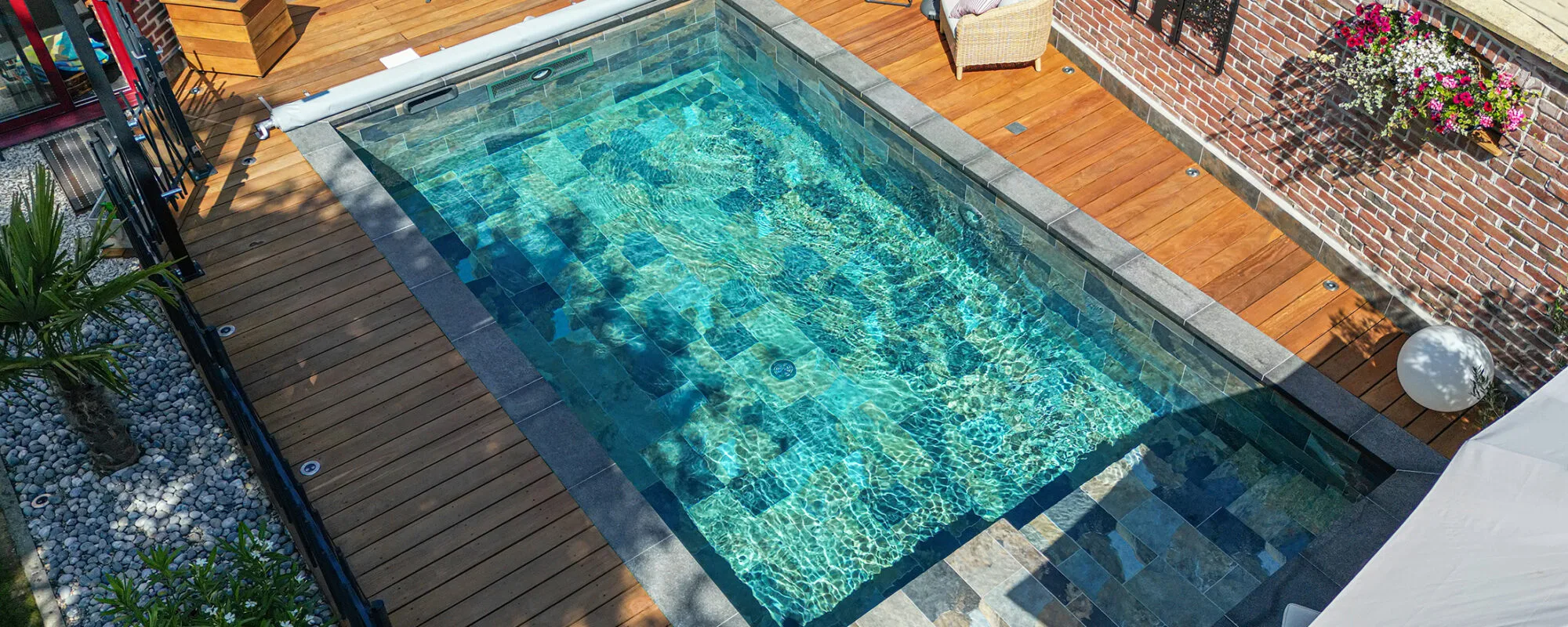 Piscine sur mesure avec intégration d'une turbine de nage à contre-courant et un espace détente extérieur. © L'Impression Responsable - Piscine & Jardin