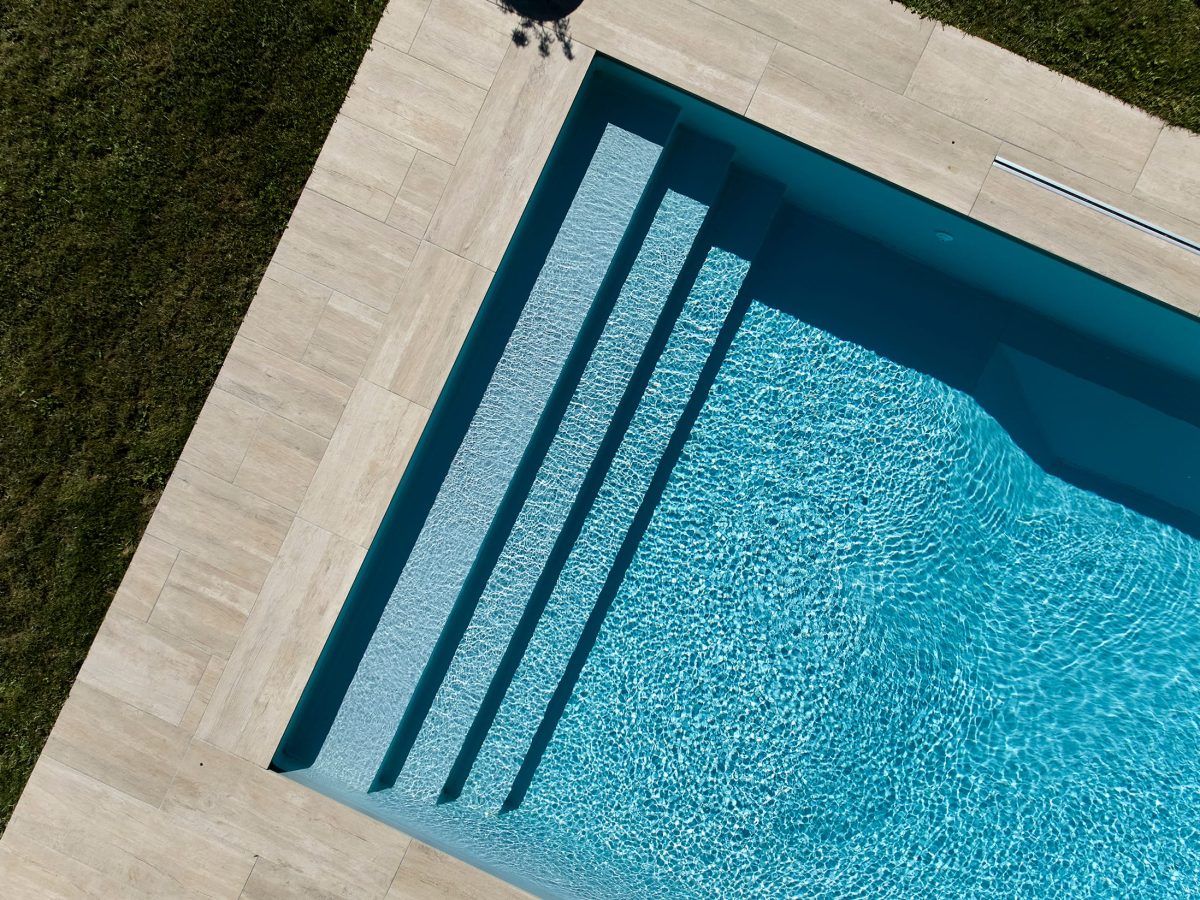 Piscine rectangulaire 10x4 avec abri plat, plage et lagon grès cérame