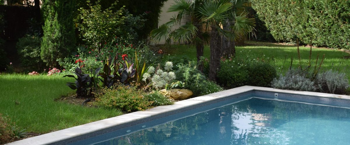 Piscine rectangulaire 9x4 avec volet motorisé , margelles en pierres naturelles avec une terrasse en bois