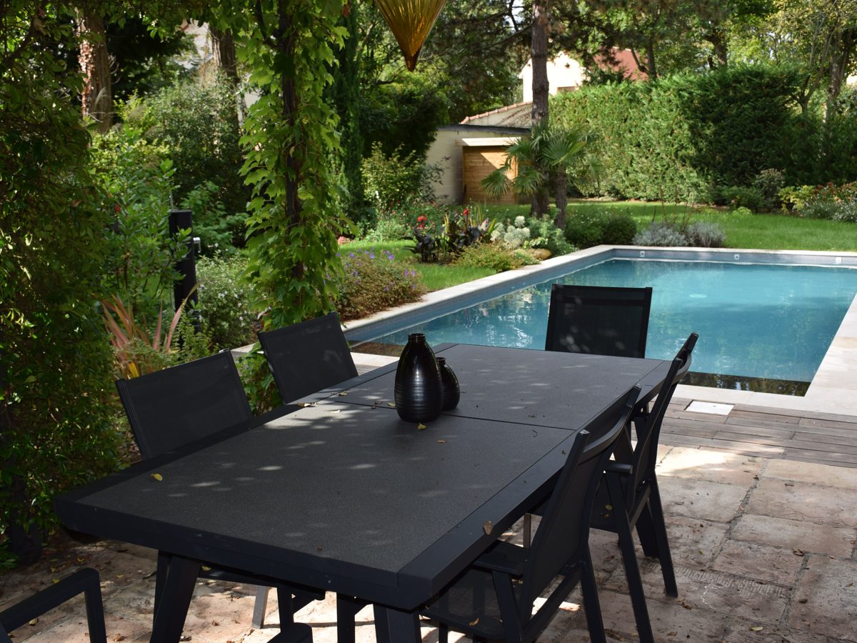 Piscine rectangulaire 9x4 avec volet motorisé , margelles en pierres naturelles avec une terrasse en bois