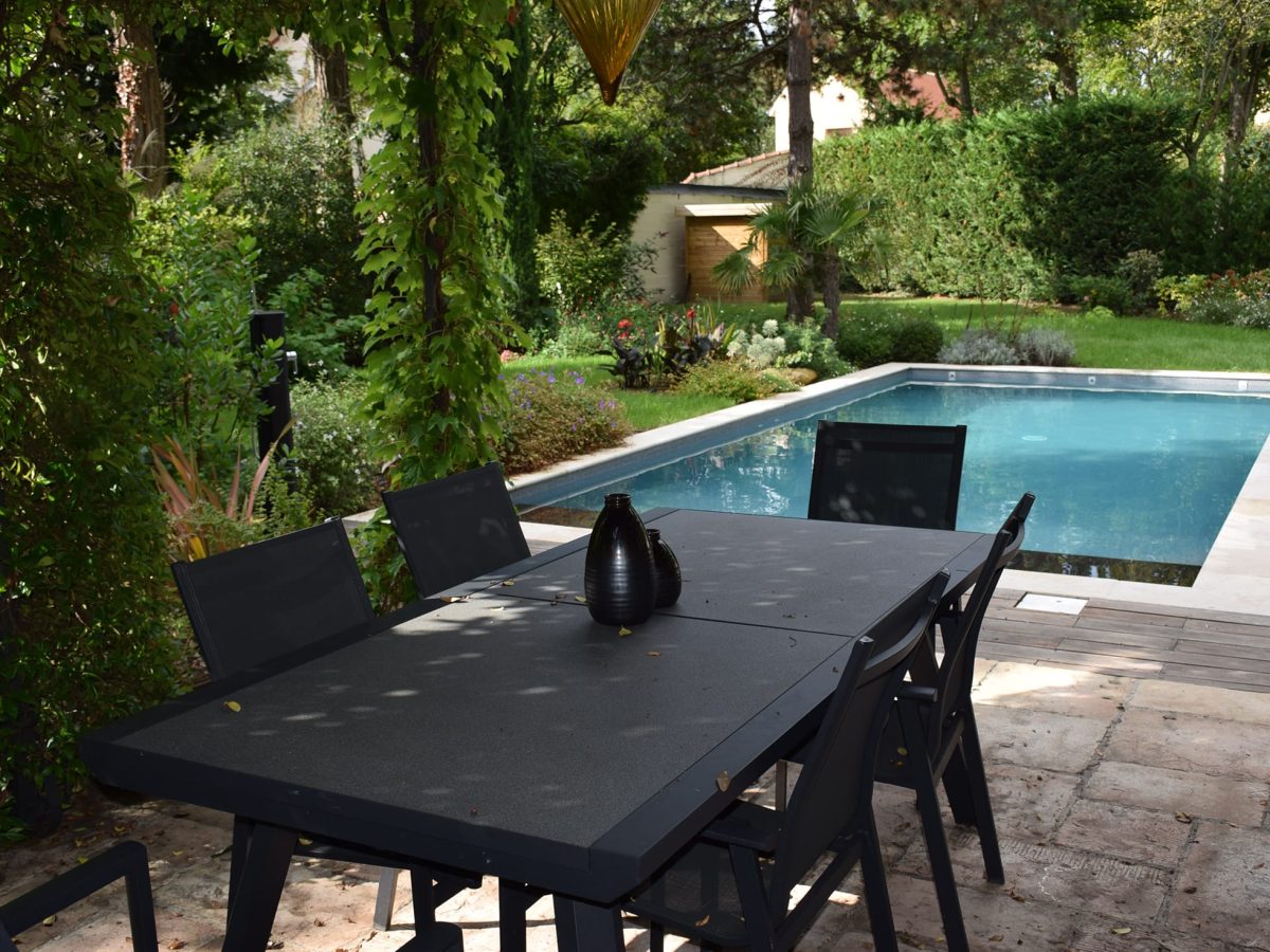 Piscine rectangulaire 9x4 avec volet motorisé , margelles en pierres naturelles avec une terrasse en bois