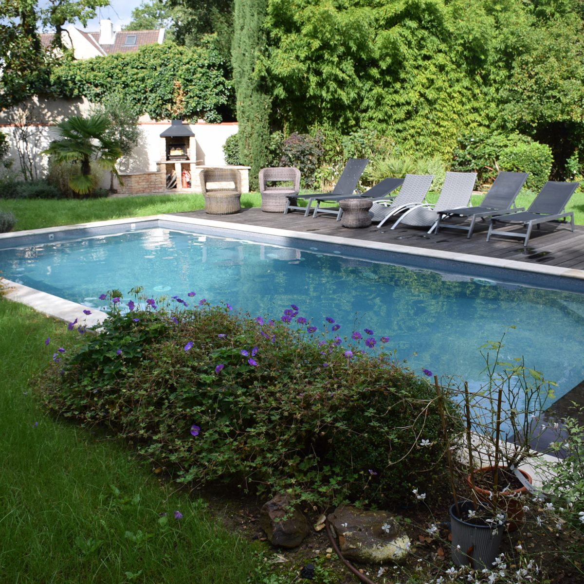 Piscine rectangulaire 9x4 avec volet motorisé , margelles en pierres naturelles avec une terrasse en bois