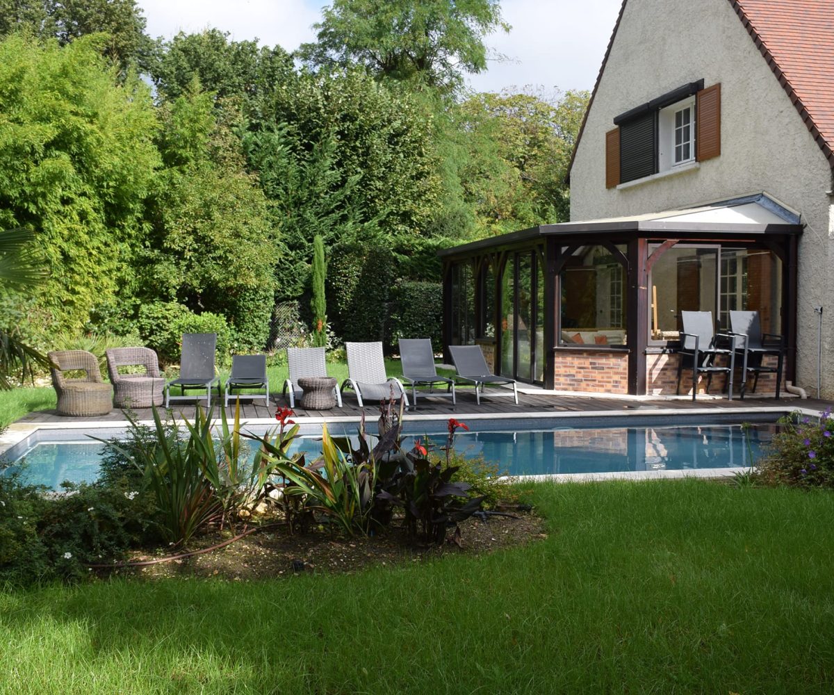 Piscine rectangulaire 9x4 avec volet motorisé , margelles en pierres naturelles avec une terrasse en bois